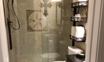 The Lone Star bathroom contains a tiled walk-in shower and marble vanity sink.